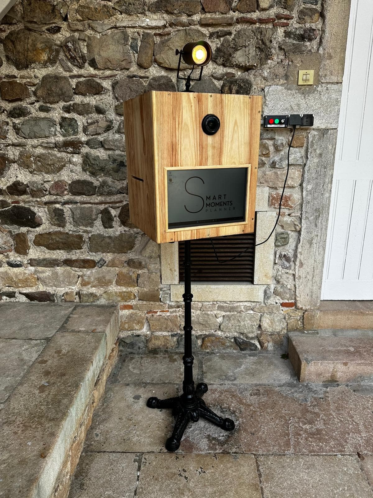 Photobooth installé en extérieur devant un mur en pierre