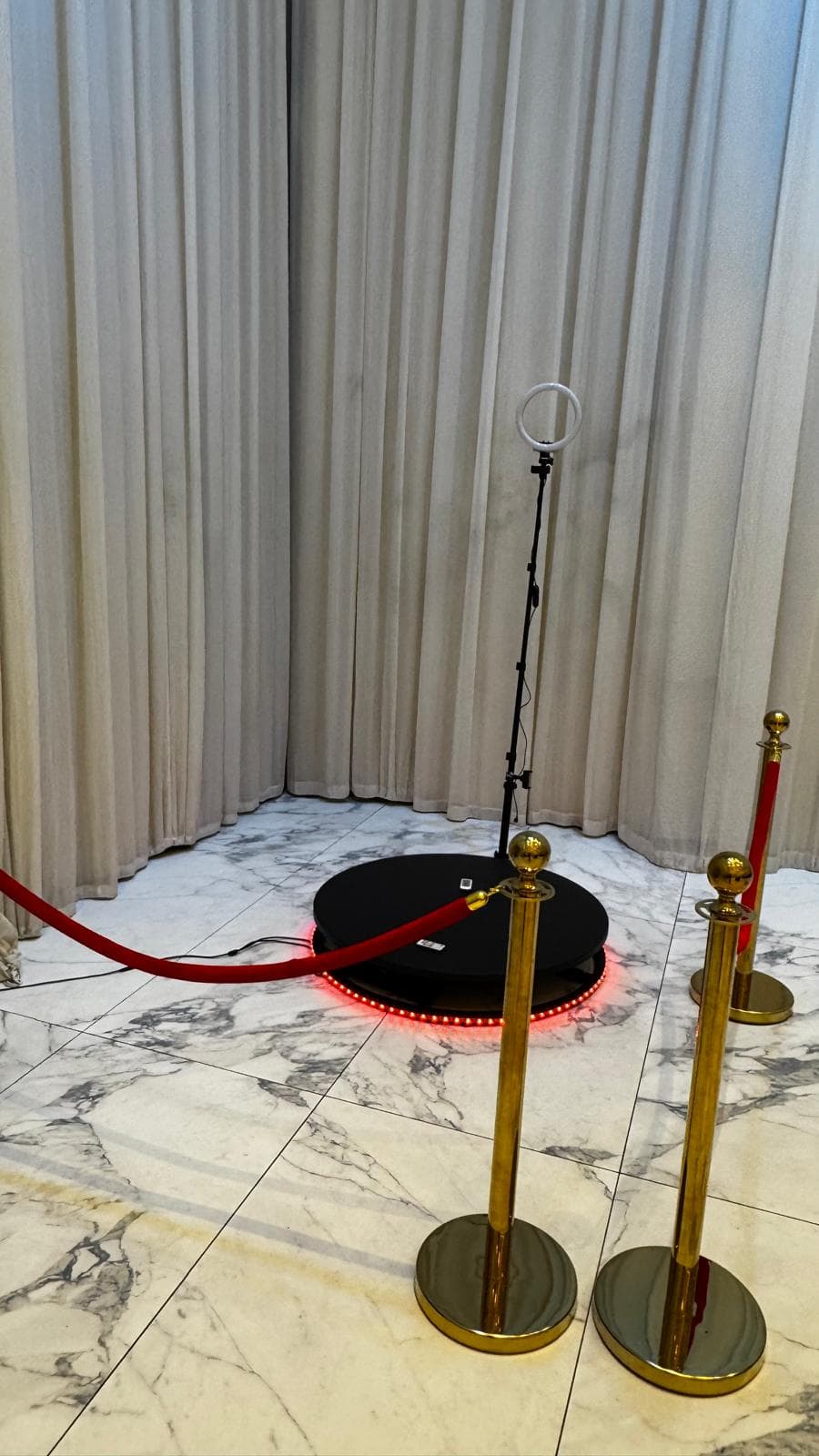 Vidéobooth 360° avec plateforme LED rouge et poteaux dorés